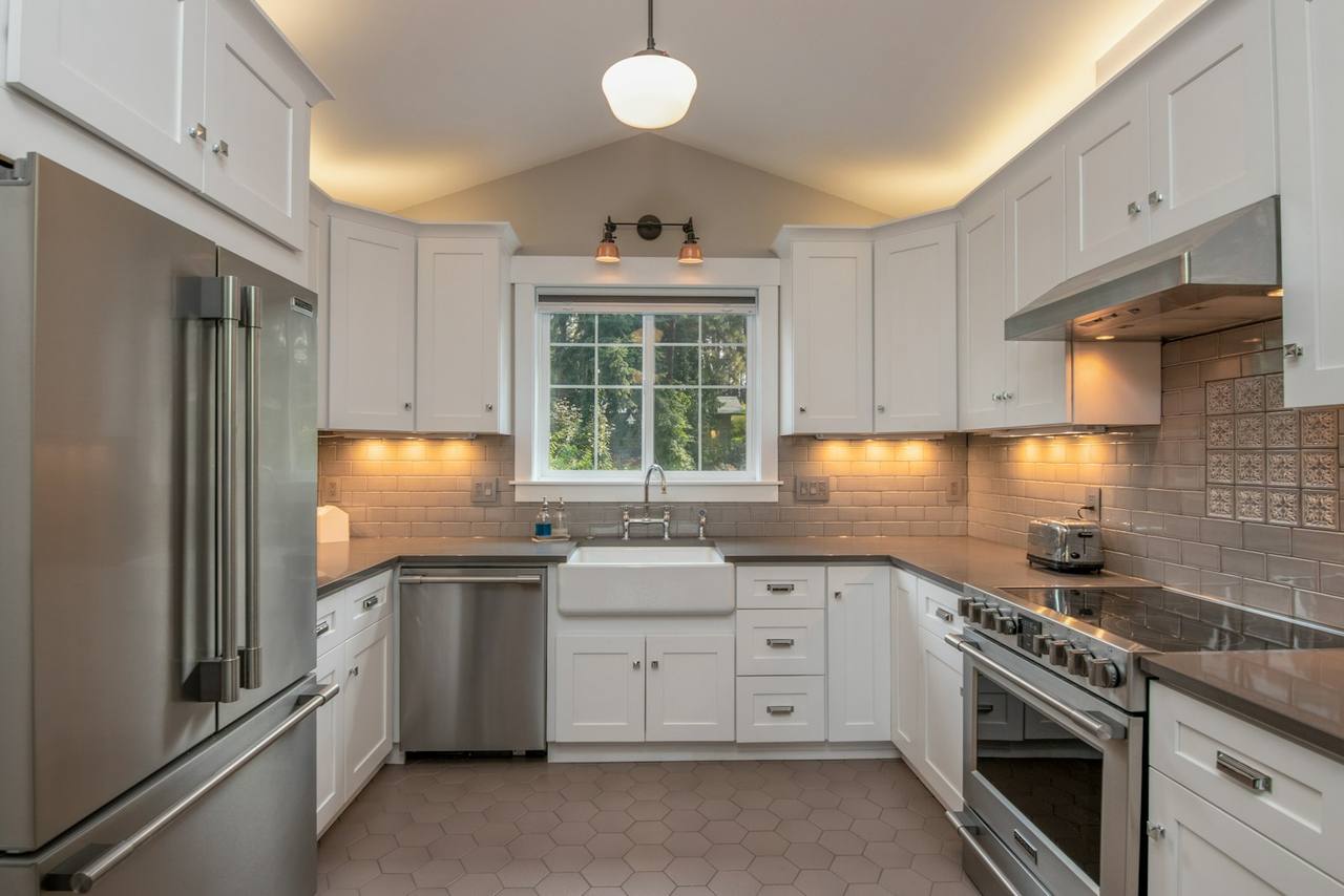 Modern kitchen with freshly painted white shaker cabinets, subway tile and under-cabinet lighting
