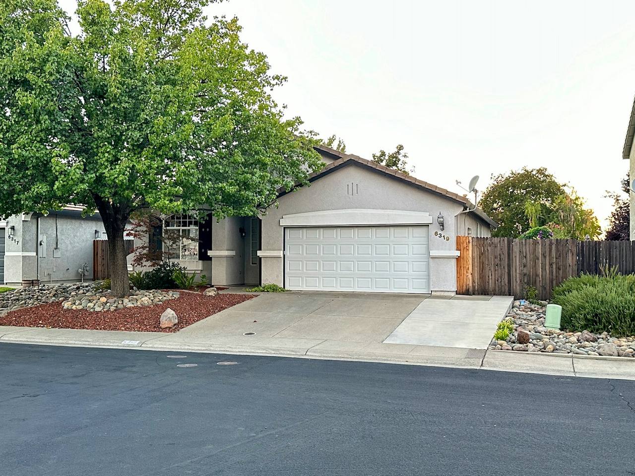 Single-story home with a clean white two-car garage door and a tidy driveway